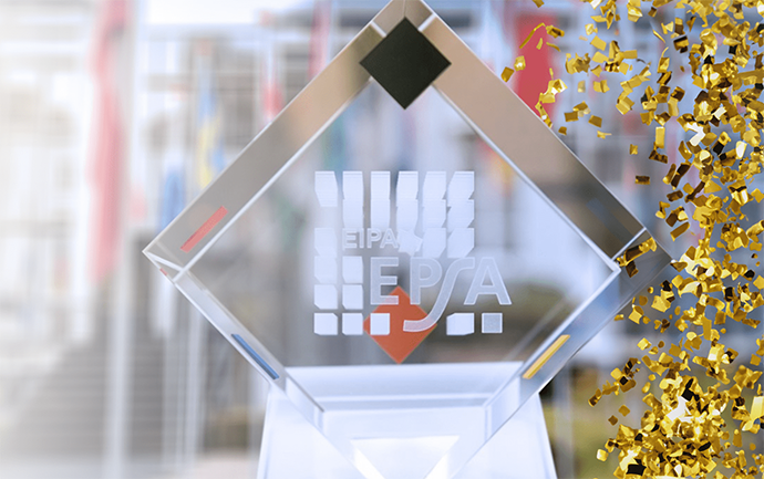 Crystal award trophy with the EPSA logo engraved on the front, displayed against a blurred background, with gold confetti falling along one side.