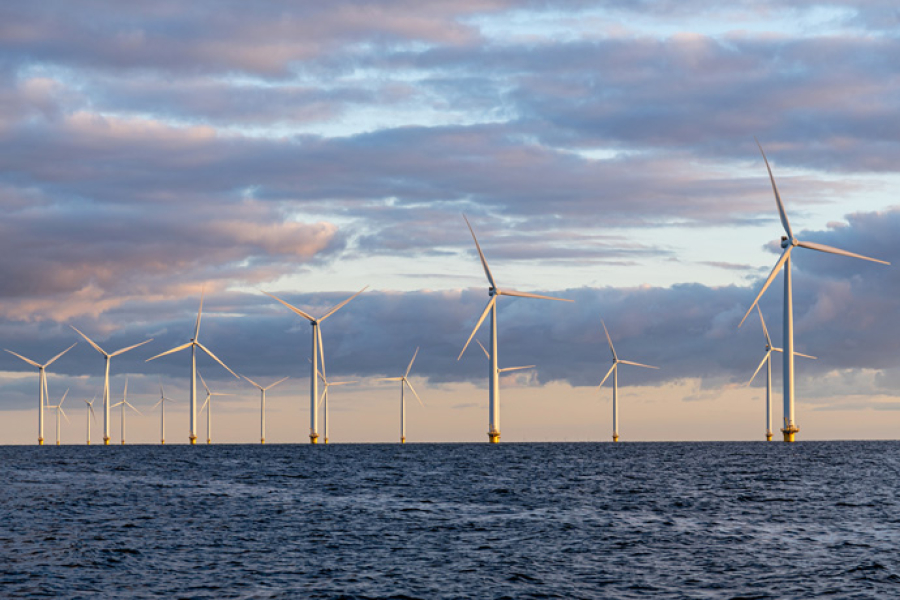 Offshore wind farm at dusk with clouds above