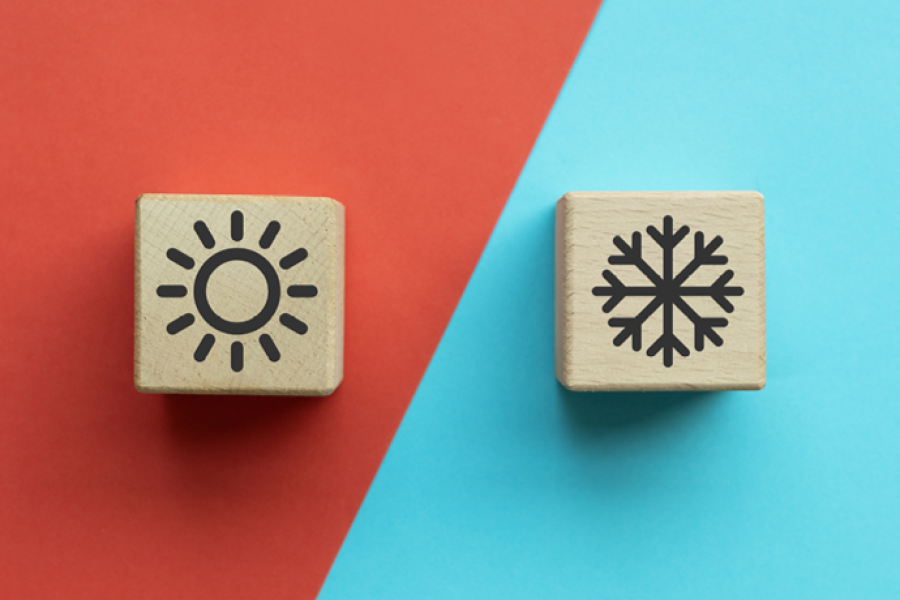 Sun and snowflake icons on wooden blocks against red and blue backgrounds.