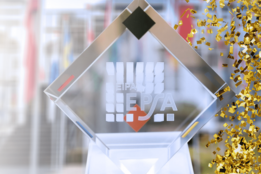 Crystal award trophy with the EPSA logo engraved on the front, displayed against a blurred background, with gold confetti falling along one side.