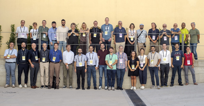 A group of 34 people split in two rows posing for photo