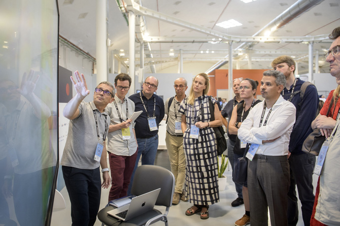 Group of 10 people with one of them pointing to a screen