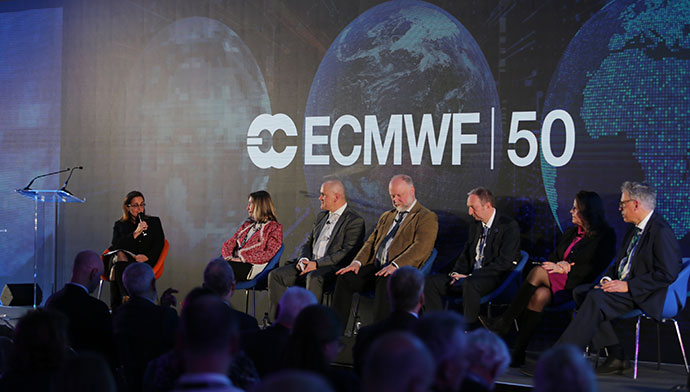 Seven people sat on chairs in front of a screen with the ECMWF 50 logo overlaid on three globes. One person has a microphone