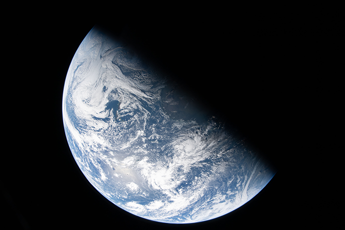 Half of Earth visible from space with half covered by blackness