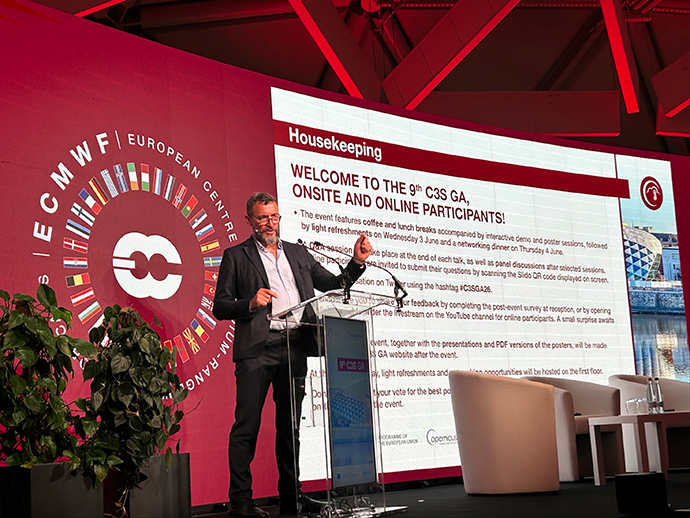 Carlo Buontempo stood in front of a large screen with a red background, the ECMWF logo and a welcome to the C3S GA slide