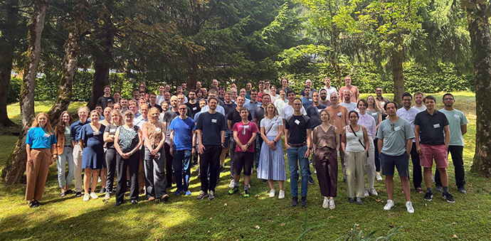 Large group of people among trees posing for a photo