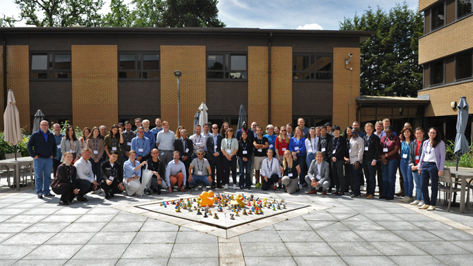 Large group of people outside on a patio in front of a building posing for group photo